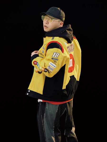 레이싱 재킷은 제이디스포츠 by ETC 서울, 멀티 색상의 후드는 엠에스지엠, 와이드 팬츠는 뮌, 검은색 야구 모자는 엄브로, 노란색 틴트 선글라스는 씬넘버포 제품.